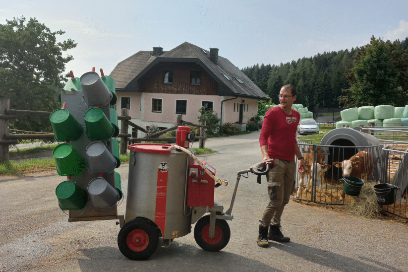 Eine Eimerhalterung am Milchtaxi verhindert doppelte Arbeitswege.